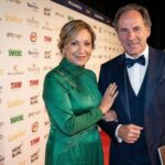 AC Milan legend Franco Baresi standing at a red carpet event beside his wife, Maura Lari, who is wearing an elegant green dress.