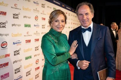 AC Milan legend Franco Baresi standing at a red carpet event beside his wife, Maura Lari, who is wearing an elegant green dress.