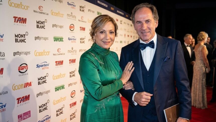 AC Milan legend Franco Baresi standing at a red carpet event beside his wife, Maura Lari, who is wearing an elegant green dress.