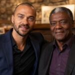 Actor Jesse Williams sitting closely and smiling with his father, Reginald Williams.