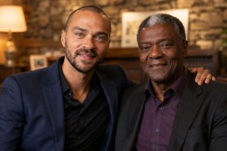 Actor Jesse Williams sitting closely and smiling with his father, Reginald Williams.