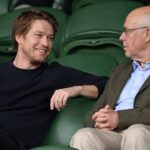 Joe Alwyn in conversation with an older companion at Wimbledon