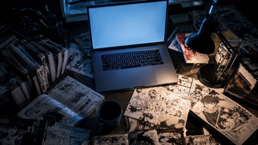 weebcentral, A dimly lit desk featuring an open laptop with a blank blue screen, surrounded by stacks of manga volumes and scattered manga pages.