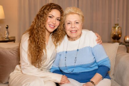 Global music star Shakira sitting affectionately on a couch with her mother, Nidia del Carmen Ripoll Torrado, both smiling warmly at the camera.