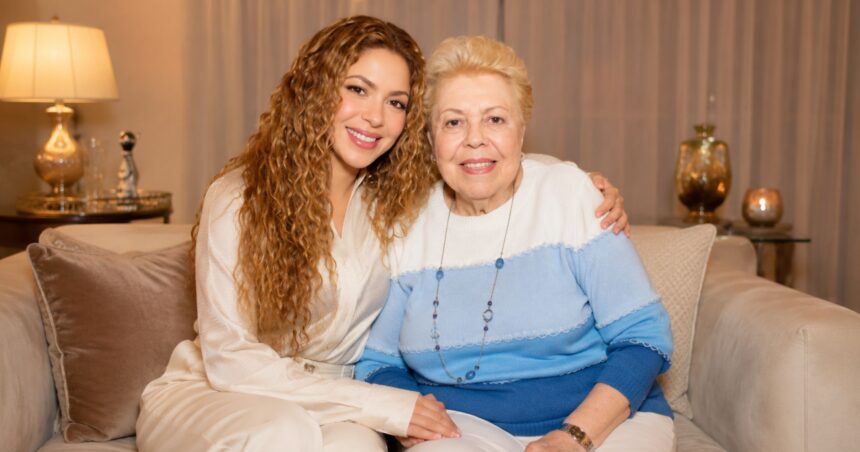 Global music star Shakira sitting affectionately on a couch with her mother, Nidia del Carmen Ripoll Torrado, both smiling warmly at the camera.