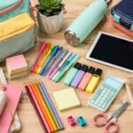 Colorful back-to-school shopping supplies, backpack, notebooks, pens, lunch box and tablet arranged for the 2026 school year.