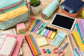 Colorful back-to-school shopping supplies, backpack, notebooks, pens, lunch box and tablet arranged for the 2026 school year.