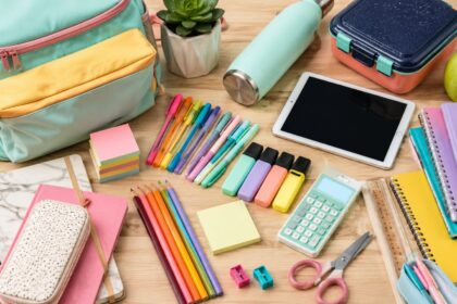 Colorful back-to-school shopping supplies, backpack, notebooks, pens, lunch box and tablet arranged for the 2026 school year.