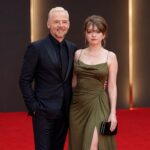 Father and daughter posing together on the red carpet at a London film premiere