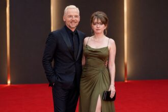 Father and daughter posing together on the red carpet at a London film premiere
