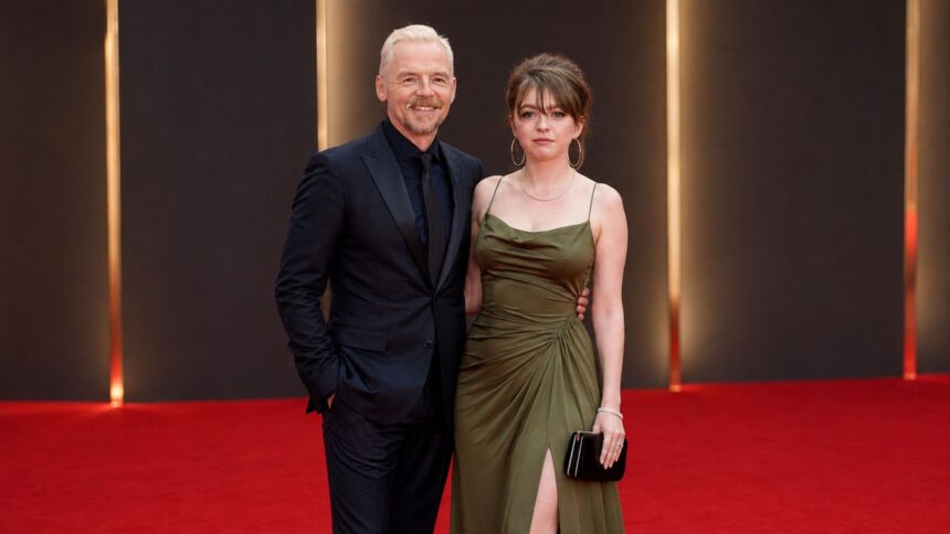 Father and daughter posing together on the red carpet at a London film premiere