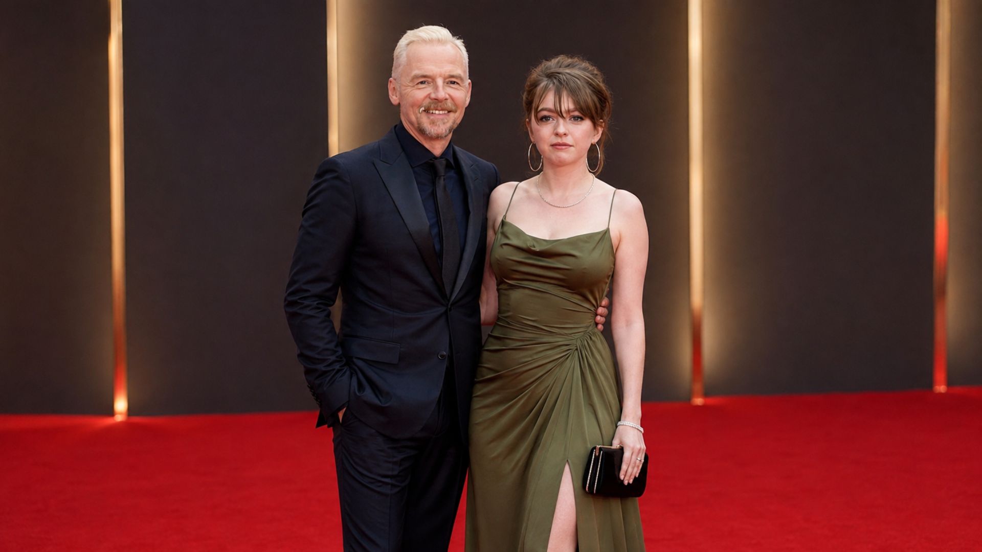 Father and daughter posing together on the red carpet at a London film premiere