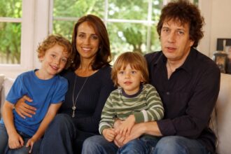 A portrait of broadcast journalist Rachel Royce and columnist Rod Liddle sitting on a sofa with their two young sons, Tyler and Wilder.